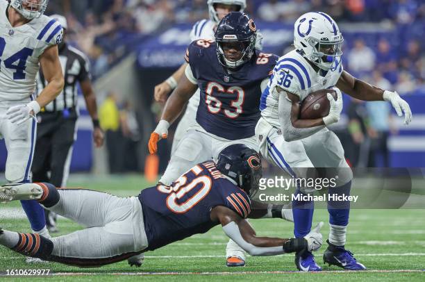 Henry Black of the Indianapolis Colts runs the ball as Davion Taylor of the Chicago Bears makes the tackle during a preseason game at Lucas Oil...
