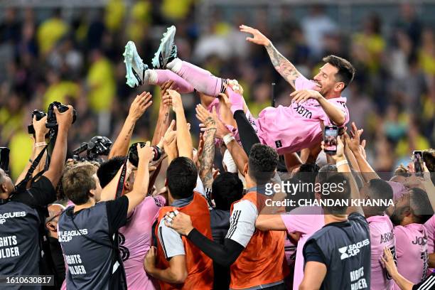 Teammates hold up Inter Miami's Argentine forward Lionel Messi as they celebrate after winning the Leagues Cup final football match against Nashville...