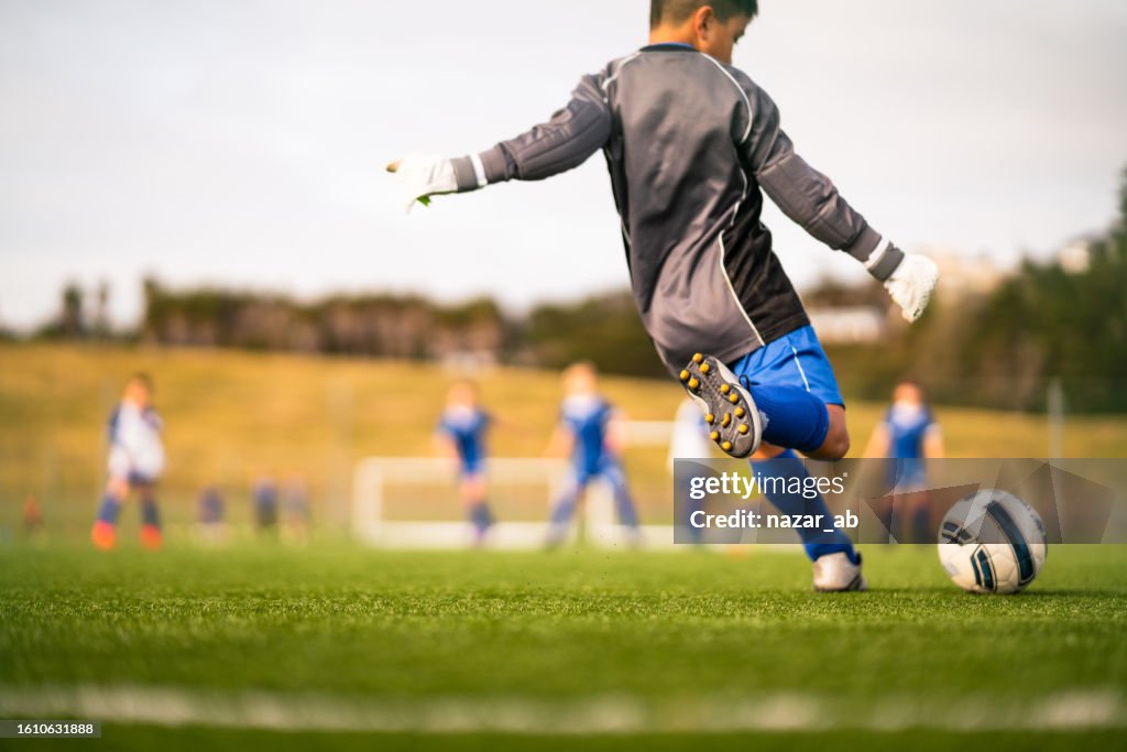 Bambino che gioca a calcio nel parco locale.
