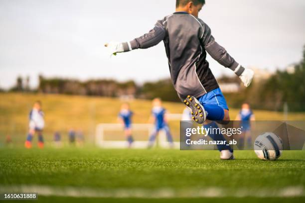 kid playing soccer in local park. - child kicking stock pictures, royalty-free photos & images