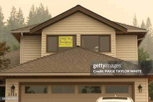 Thank you all firefighters" sign is put in the front window of a house near Shannon Lake as the nearby McDougall Creek wildfires continue in West...