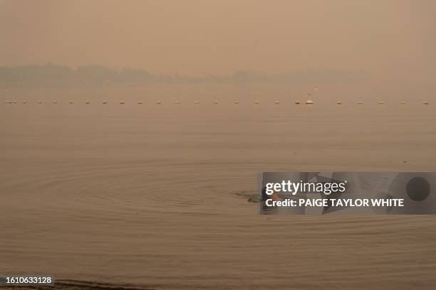 Sarah Sokoloski 20, swims in Lake Okanagan covered in wildfires smoke in West Kelowna, British Columbia on August 19, 2023. Residents of western...