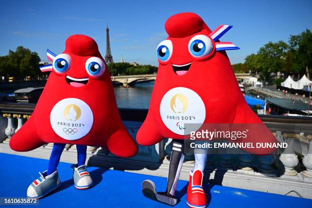 Olympic Phryges mascots pose for a photograph on the Alexandre III bridge with the Eiffel Tower in the background after the mixed relay of the 2023...
