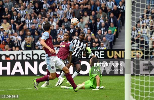 Alexander Isak of Newcastle United chips Emiliano Martinez to score the team's third goal during the Premier League match between Newcastle United...