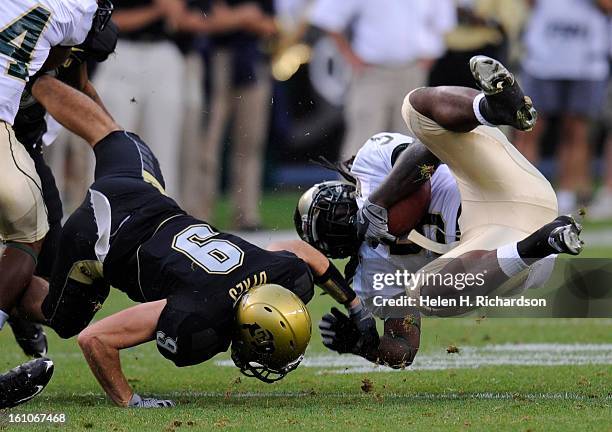 S running back Gartrell Johnson III, right, gets upended by CU's safety Daniel Dykes in the 3rd quarter at Invesco Field at Mile High in the opening...