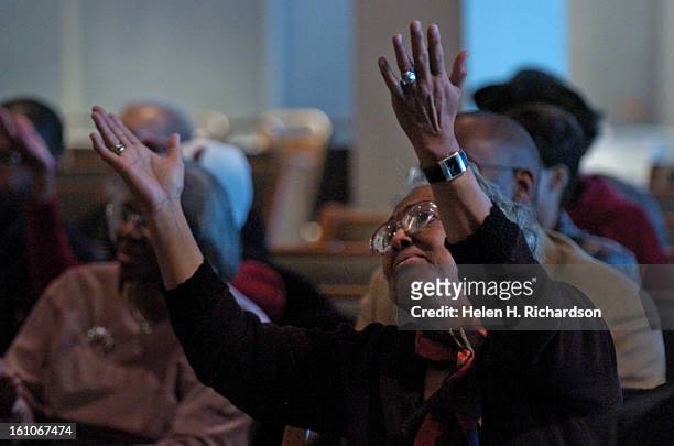Genevieve Smith lifts up her hands to join in the singing during the service of her friend. A memorial service celebrating and honoring the life of...