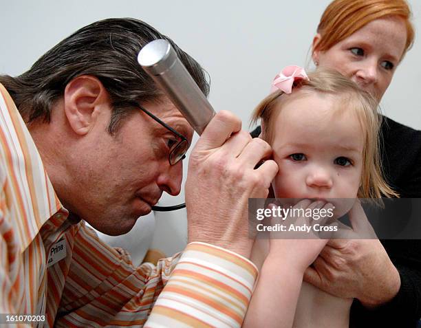EARINFECTIONa--Dean Prina, M.D., <cq> checks inside of 18-month-old, Ashby Burnett's ear during a well baby check-up at Partners in Pediatrics office...
