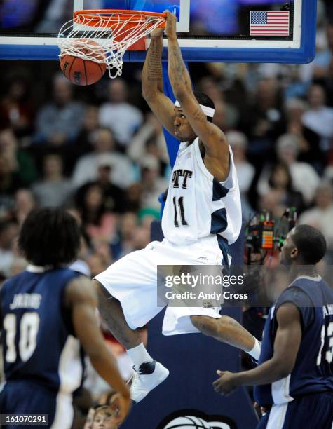 Gilbert Brown, Pittsburgh, slam dunks against Oral Roberts, Robert Jarvis, left, and Moses Ehambe, in the second half of play during the 1st round of...