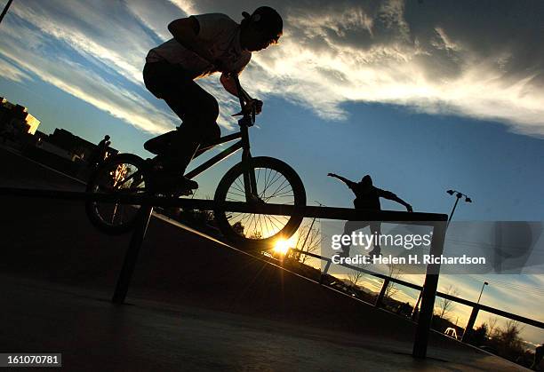 Derek Reinhardt <cq> 19 <cq> of Denver <cq> does some tricks on his bike at the skatepark near LoDo. Temperatures reached 70 degrees and the sunset...