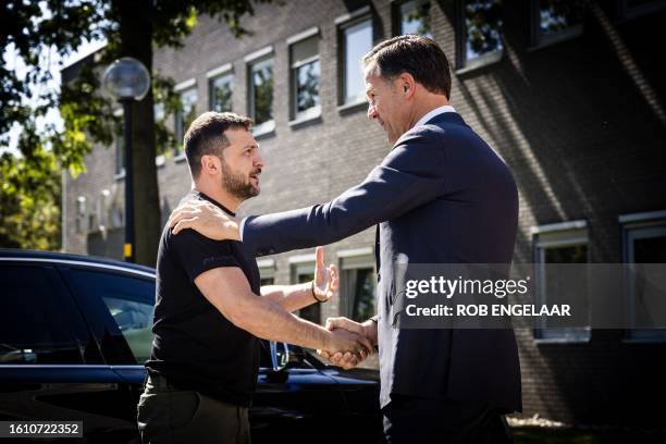 Ukrainian President Volodymyr Zelensky and outgoing Dutch Prime Minister Mark Rutte shake hands during a visit to the Eindhoven Military Air Base, in...