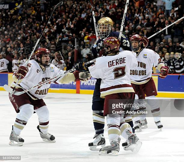 Mark Van Guilder, #23, Notre Dame, second from left, gets stuck in between, Boston's Ben Smith, left, Nathan Gerbe, center, and Benn Ferriero, right,...