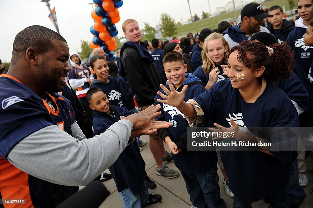 (HR) ABOVE: Denver Broncos Daryl Hackney, left tries to beat Jocelyne Raygoza, 12 at a game of Rock, Scissors, Paper or Ro Sham Bo (check spelling.) In celebration of fitness, children from all eight branches of the Boys & Girls Clubs of Metro Denver part