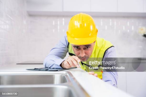 a house inspector measured a level of the kitchen counter in a new house - counter surface level stock pictures, royalty-free photos & images
