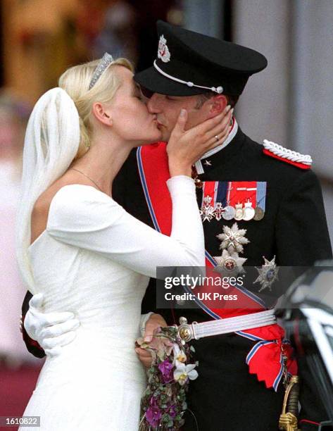 Norwegian Crown Prince Haakon and Mette-Marit Tjessem Hoiby kiss at the Oslo Cathedral August 25, 2001 after their wedding.