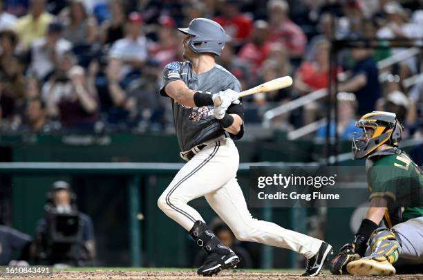 Lane Thomas of the Washington Nationals hits an RBI single in the eighth inning against the Oakland Athletics at Nationals Park on August 12, 2023 in...