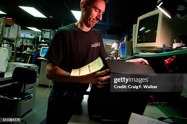 2006__Olivier Gerber, lead technician at Action Computers, inc. In Denver, CO, works on an IBM computer. The computer had been dropped off to have a...