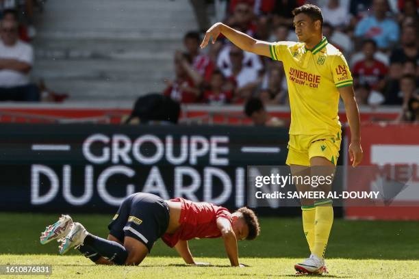 Nantes' Egyptian forward Mostafa Mohamed reacts as Lille's Portuguese defender Tiago Santos falls during the French L1 football match between Lille...