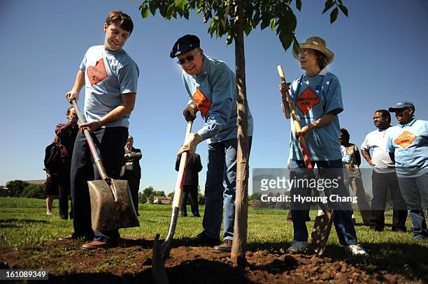 DNC28carter_ Former president Jimmy Carter, center, and his wife Rosalyn, right, and their grand son Jason are tree planting during their...