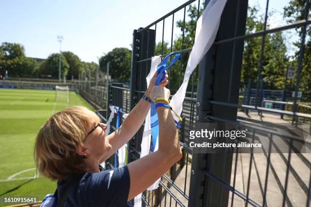 August 2023, Berlin: Regionalliga women: Hertha BSC - Union Berlin. Inis hangs blue and white ribbons on a fence before the women's regional league...
