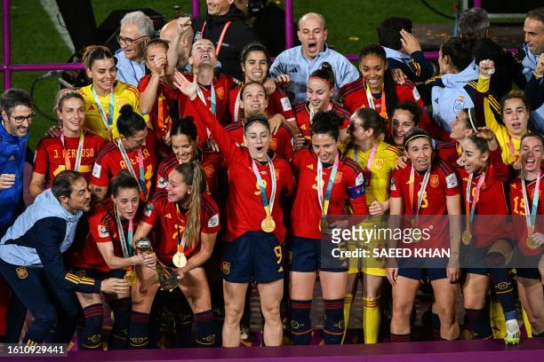 Spain's players and coaching staff celebrate with the trophy on the podium after winning the Australia and New Zealand 2023 Women's World Cup final...