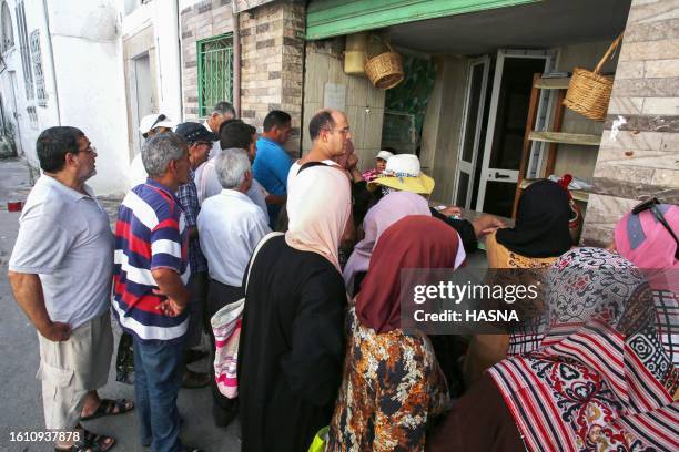 People queue in front of a bakery selling subsidised bread in Tunis' Halfaouine district, on August 19, 2023. Tunisia is reinstating subsidised flour...