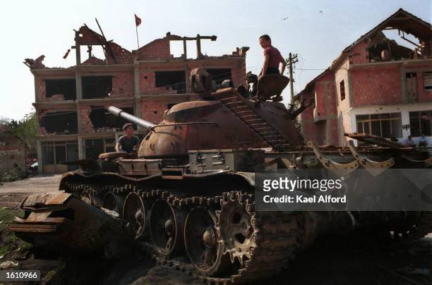Albanian children play on a damaged Macedonian tank August 27, 2001 in the village of Matejce near Kumanovo, Macedonia. The region is the first rebel...