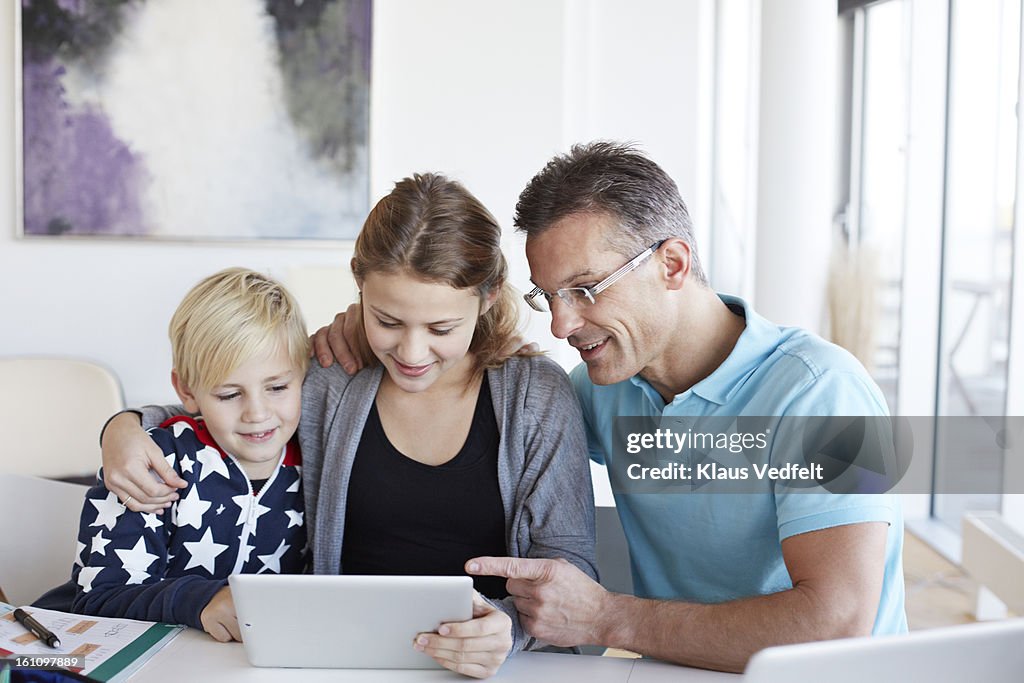 Father and kids looking at tablet