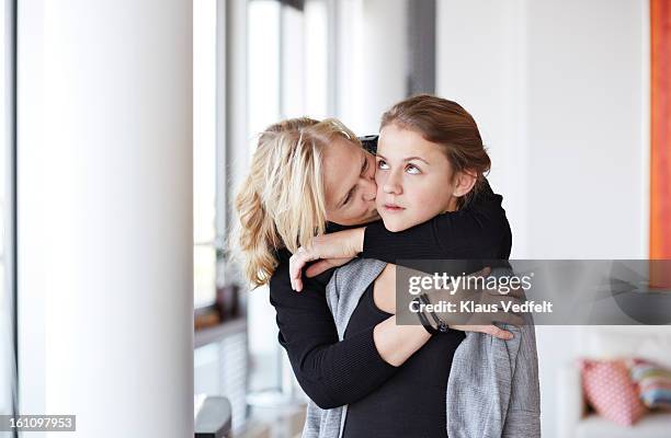 mother kissing & hugging her daughter - schaamte stockfoto's en -beelden