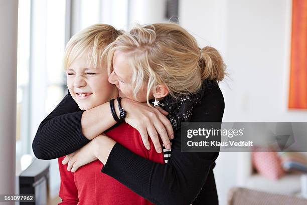 mother hugging her son - awkward family photo stock pictures, royalty-free photos & images