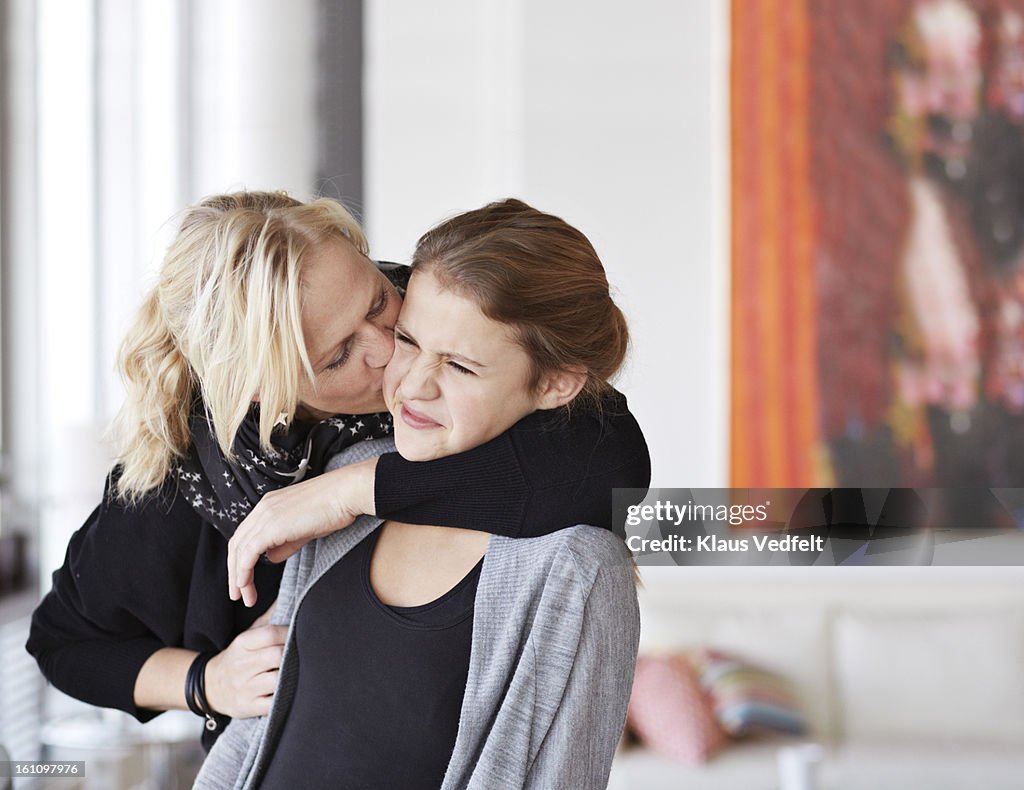 Mother kissing and hugging her daughter
