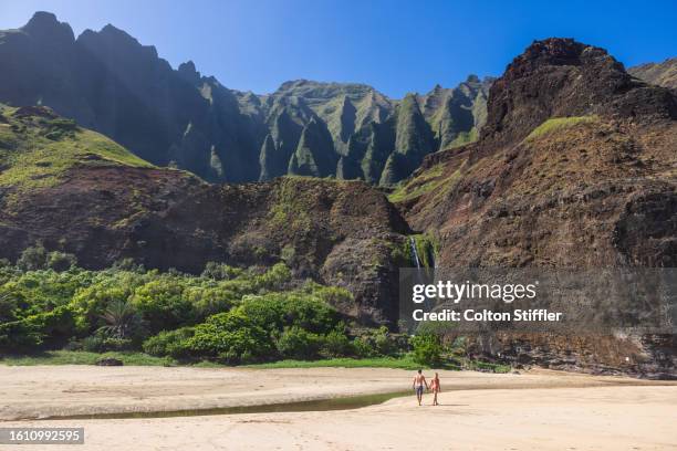 strolling along kalalau beach on the napali coast in kauai, hawaii - kauai stock pictures, royalty-free photos & images