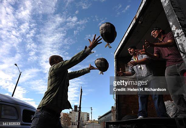 Turkeys get tossed in the air toward Denver Rescue Mission residents Chris Westover,middle and Nick Curiazza, right. The two are program candidates...