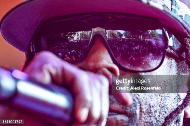 The crowd of people are reflected on the lens a hip hop artist's glasses at the fiftieth anniversary of Hip Hop block party near 1520 Sedgwick Ave on...