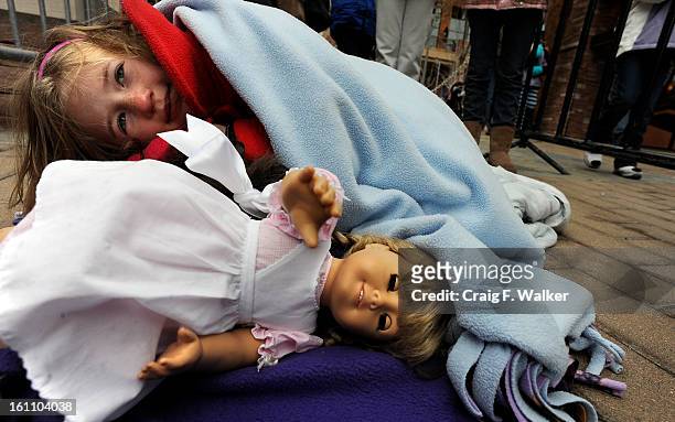 Maeve Layne of Aurora, uses a blanket to stay warm while waiting, with her doll, Samantha, for the grand opening of American Girl at Park Meadows, in...