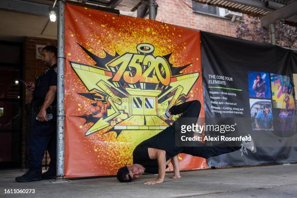 Person breakdances outside of the 1520 Sedgwick Ave building at the fiftieth anniversary of Hip Hop block party on August 12, 2023 in The Bronx...