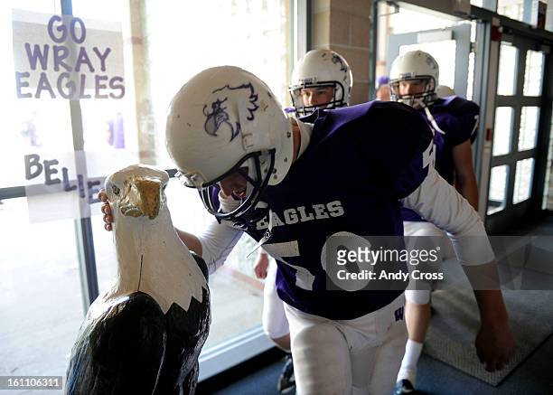 Wray Eagles OL/LB/K, Annton Vappula, rubs the Eagle statues head along with his teammate before taking the field to play the Burlington Cougars at...