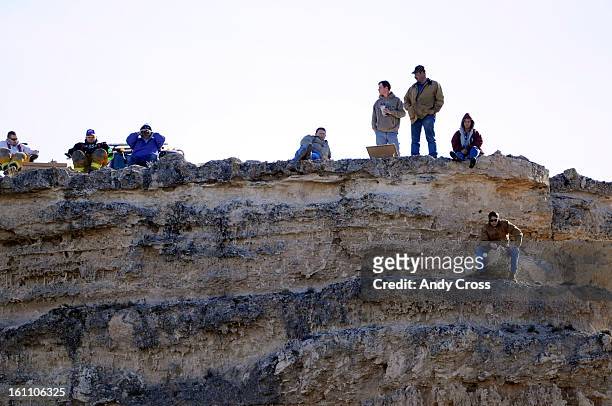 Football fans enjoy the Wray Eagles against the Burlington Cougars high atop a nearby cliff during the Colorado State 1A Championship football game...