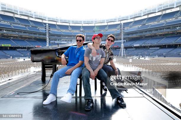 Kevin Jonas, Joe Jonas, and Nick Jonas pose onstage before Jonas Brothers "Five Albums, One Night" Tour Opening Night at Yankee Stadium on August 12,...