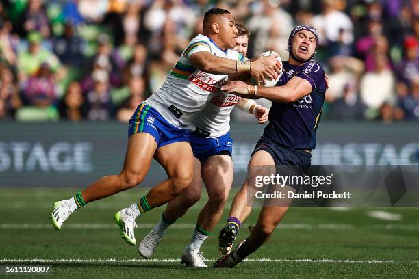 Jahrome Hughes of the Storm is tackled during the round 24 NRL match between Melbourne Storm and Canberra Raiders at AAMI Park on August 13, 2023 in...