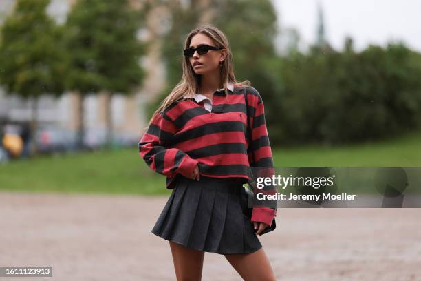 Guest seen wearing black sunnies, black and white striped Ralph Lauren shirt, grey folded mini skirt and black shiny sandals outside Opera Sport show...