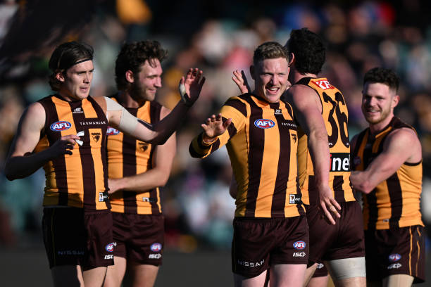 James Sicily of the Hawks celebrates the win with teammates during the round 22 AFL match between Hawthorn Hawks and Western Bulldogs at University...