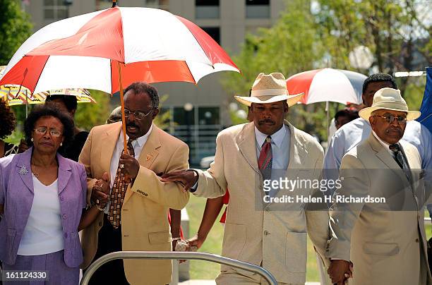Charles Jamison, second from right in hat and other members from the church pray together during the rally. Dr. Timothy E. Tyler and members of the...