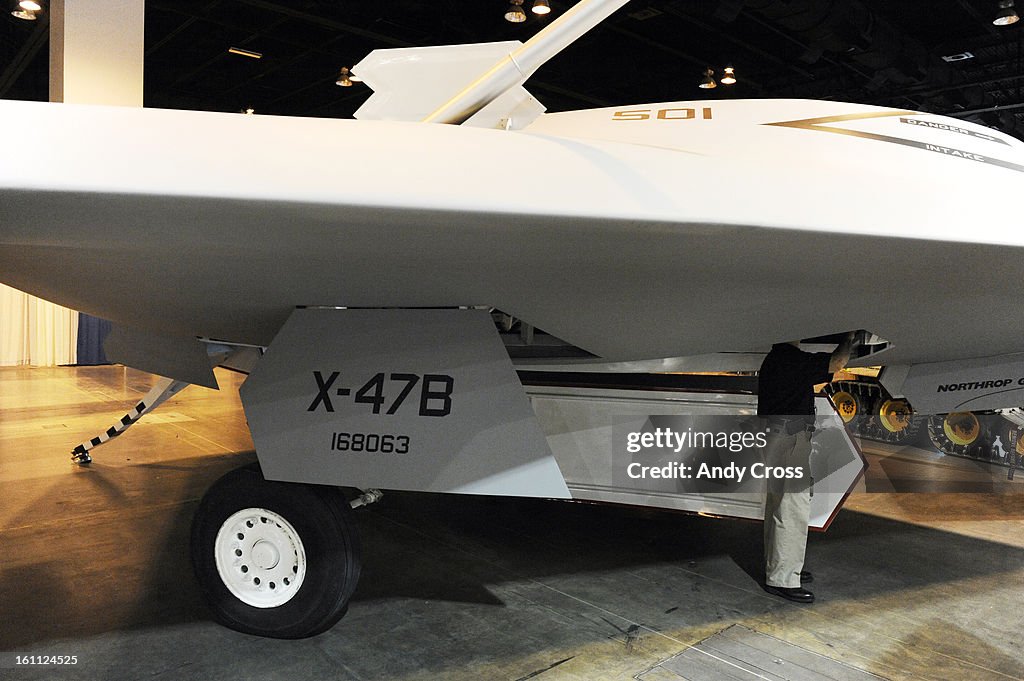DENVER, CO--AUGUST 24TH 2010--Bill Green, marketing manager for PMI Industries from Cleveland Ohio, peeks inside of Northrup Grumman's model of a X-47B, Navy Unmanned Combat Air System Demonstration at the AUVSI's Unmanned Systems North America 2010 show