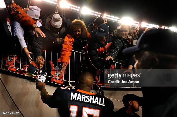 The Denver Broncos wide receiver Brandon Marshall gives one of his shoes to a young child in the stands after their win vs the New York Giants 26-6...