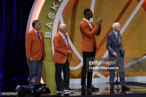 Inductee Gene Bess stands on stage with presenters John Calipari, Roy Williams and Chris Bosh during the 2023 Naismith Basketball Hall of Fame...