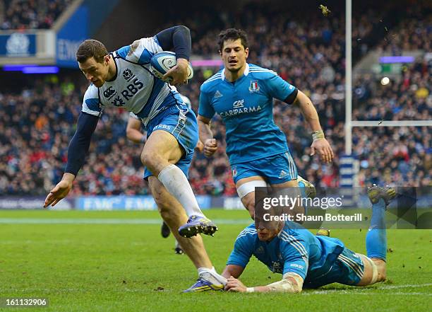 Tim Visser of Scotland breaks through the tackle of Sergio Parisse of Italy to score a try during the RBS Six Nations match between Scotland and...