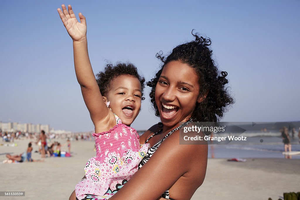 Mixed race mother and daughter enjoying the beach
