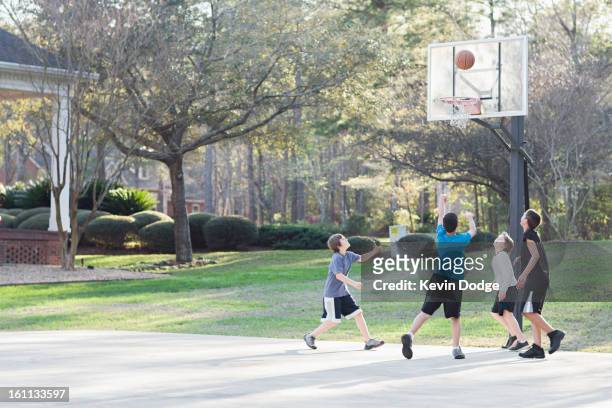 boys playing basketball - boys basketball stock pictures, royalty-free photos & images