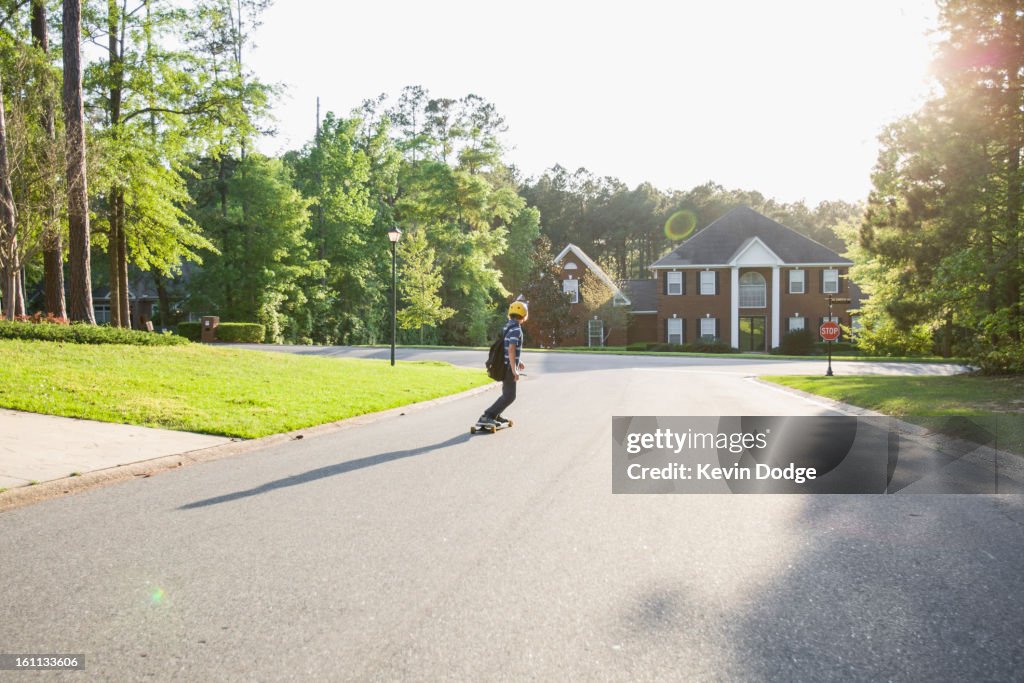 Caucasian boy skateboarding on road