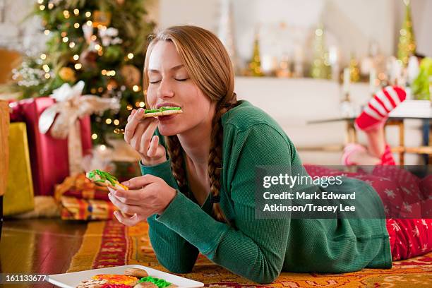 caucasian woman eating christmas cookies - frost bite stock-fotos und bilder